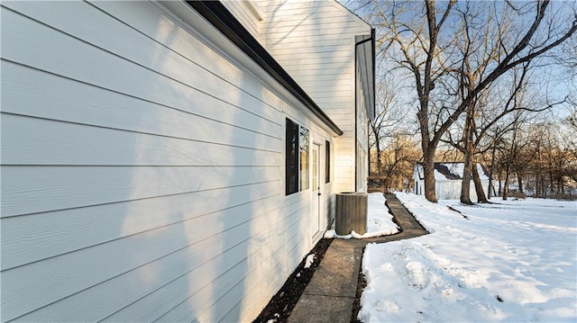 snow covered property with central AC