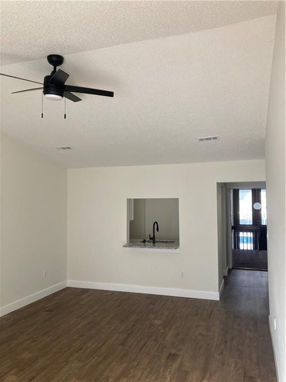 unfurnished room with ceiling fan, dark wood-type flooring, a textured ceiling, and sink