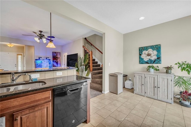 kitchen with pendant lighting, sink, light tile patterned floors, dishwasher, and dark stone countertops