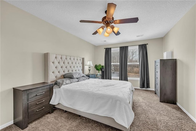 carpeted bedroom with ceiling fan and a textured ceiling