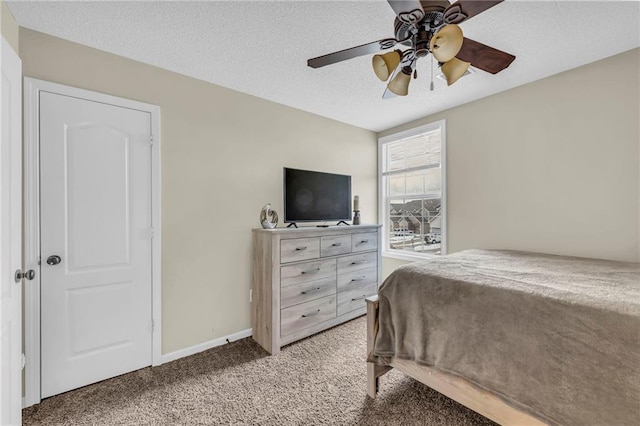 carpeted bedroom featuring ceiling fan and a textured ceiling