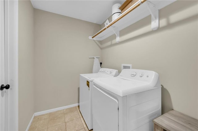 clothes washing area featuring light tile patterned flooring and washer and clothes dryer