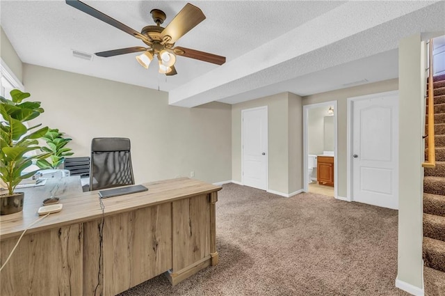 home office with ceiling fan, carpet flooring, and a textured ceiling