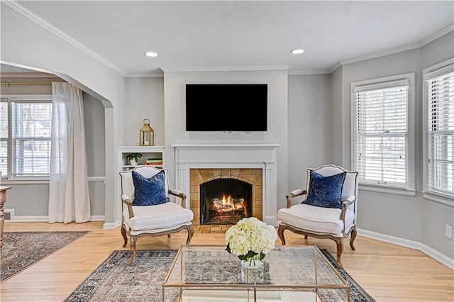 sitting room featuring crown molding, wood-type flooring, and a tile fireplace