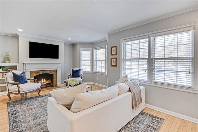 living room featuring crown molding, hardwood / wood-style floors, and a tile fireplace