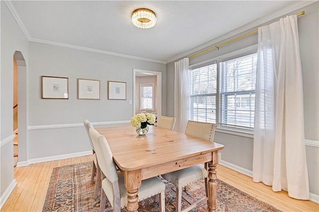 dining area with crown molding and light wood-type flooring