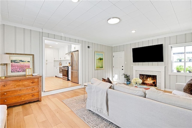 living room featuring ornamental molding and light wood-type flooring