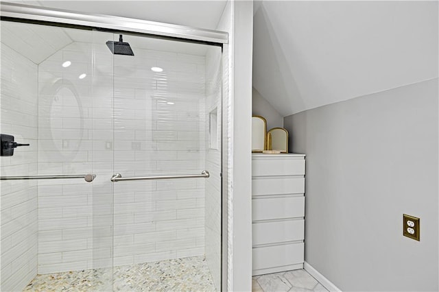 bathroom featuring vaulted ceiling and a shower with door