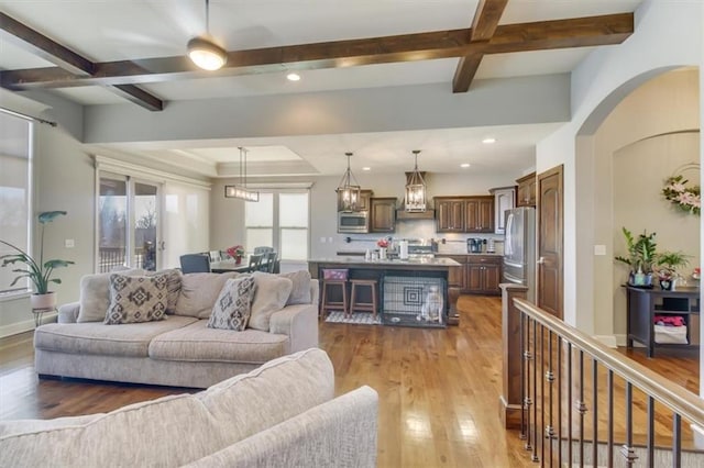 living room featuring coffered ceiling, hardwood / wood-style floors, and beam ceiling