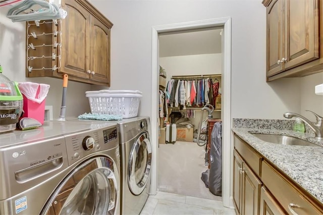 washroom featuring cabinets, light tile patterned flooring, sink, and independent washer and dryer