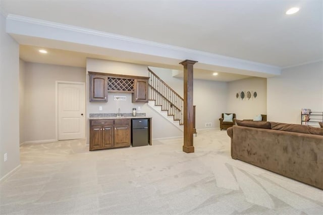 living room with crown molding, light colored carpet, and indoor bar