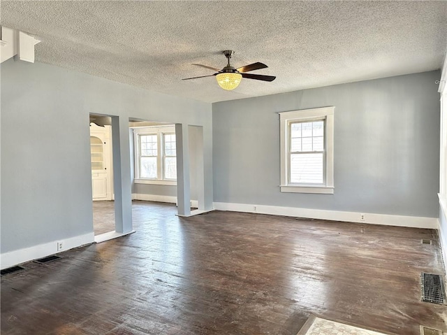 empty room featuring ceiling fan, plenty of natural light, and a textured ceiling