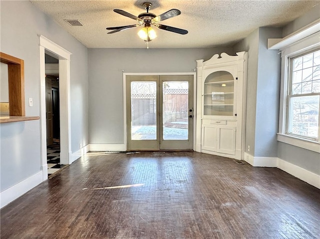 interior space featuring ceiling fan, dark wood-type flooring, and a textured ceiling