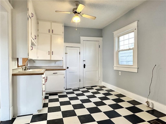 kitchen with ceiling fan, sink, white cabinetry, and a textured ceiling