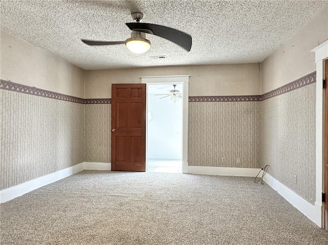 unfurnished room with ceiling fan, a textured ceiling, and carpet floors