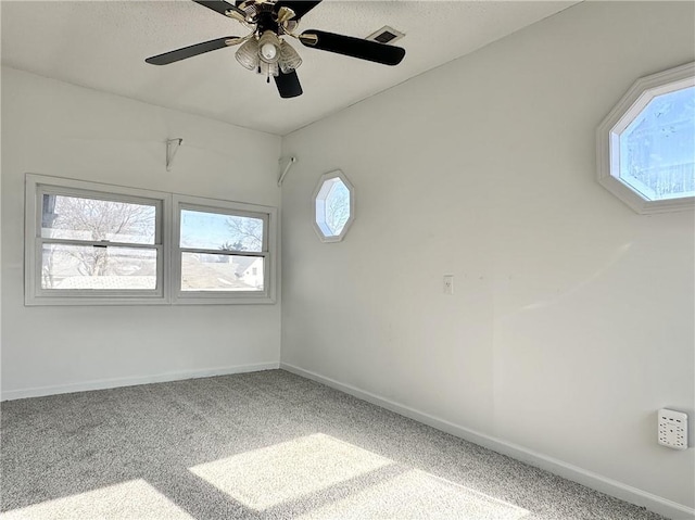 carpeted spare room with ceiling fan and a wealth of natural light