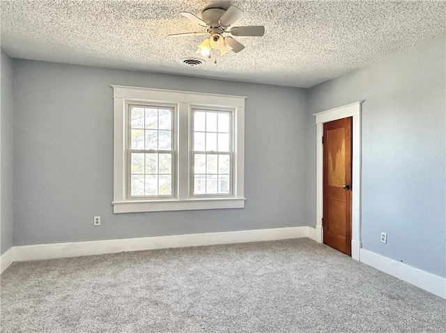 carpeted spare room with ceiling fan and a textured ceiling