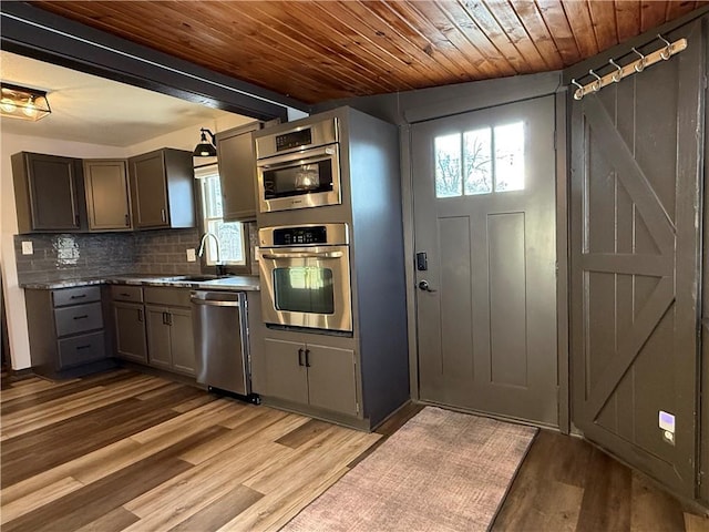 kitchen featuring stainless steel appliances, sink, decorative backsplash, and plenty of natural light