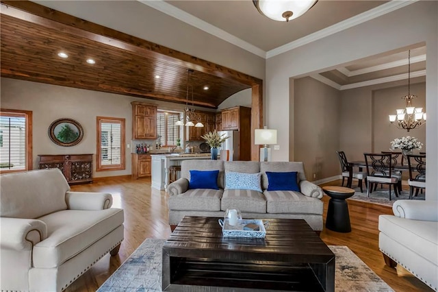 living room featuring crown molding, light hardwood / wood-style flooring, and a chandelier