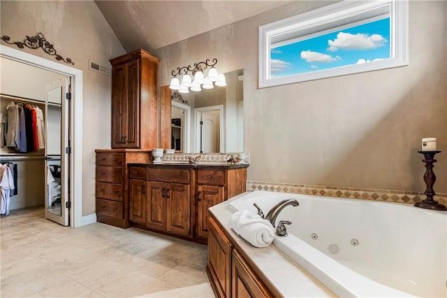 bathroom with lofted ceiling, vanity, and a bath