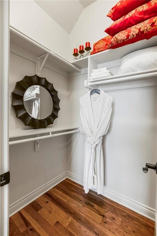 walk in closet featuring dark hardwood / wood-style flooring and vaulted ceiling