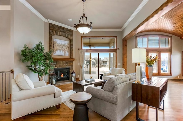 living room with ornamental molding, a wealth of natural light, and light hardwood / wood-style flooring