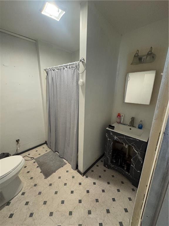 bathroom featuring sink, curtained shower, and toilet