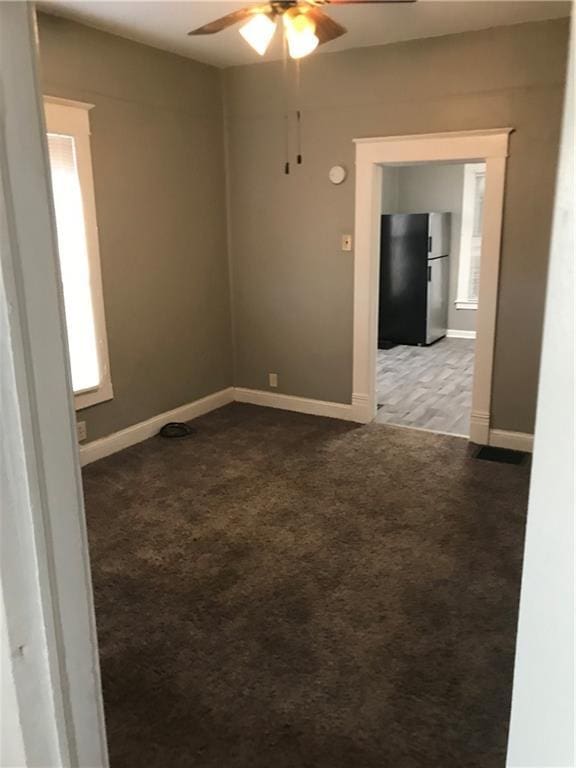 carpeted spare room with ceiling fan