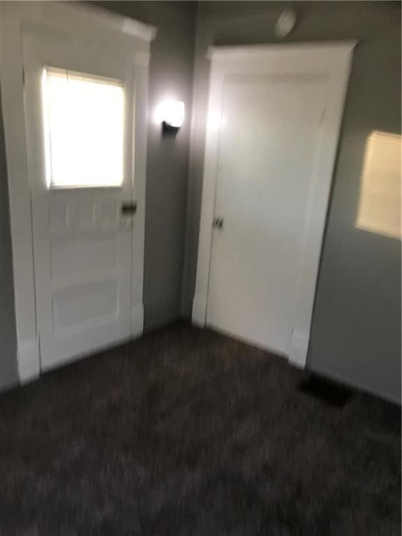 entryway with dark carpet