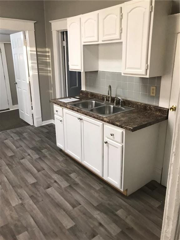 kitchen featuring tasteful backsplash, white cabinetry, sink, and dark hardwood / wood-style floors