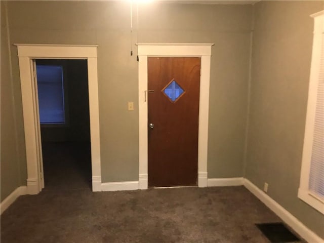 foyer with dark colored carpet