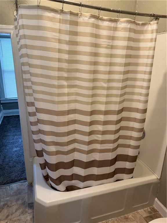 2901 Messanie St, Saint Joseph, MO 64501 - full bathroom with shower / bathtub combination with curtain, a textured wall, and baseboards