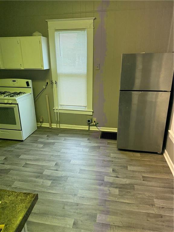 2901 Messanie St, Saint Joseph, MO 64501 - kitchen featuring freestanding refrigerator, white range with gas cooktop, baseboards, and light wood finished floors
