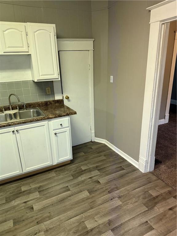 2901 Messanie St, Saint Joseph, MO 64501 - kitchen featuring a sink, baseboards, dark wood-type flooring, and dark countertops