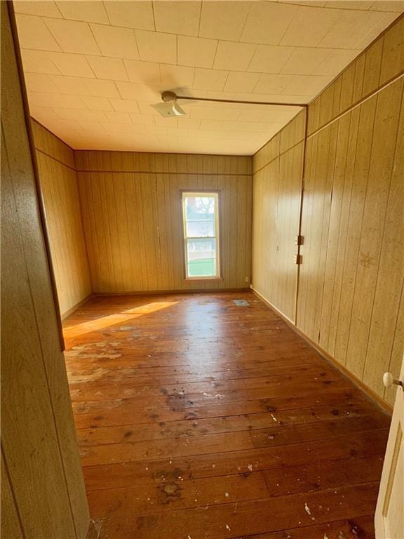 spare room featuring hardwood / wood-style flooring and wood walls