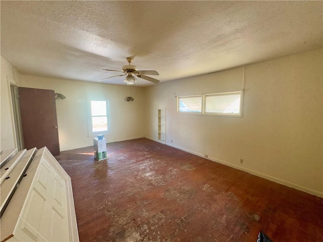 empty room with ceiling fan and a textured ceiling