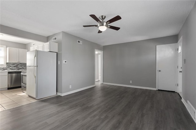 unfurnished living room with visible vents, baseboards, and wood finished floors