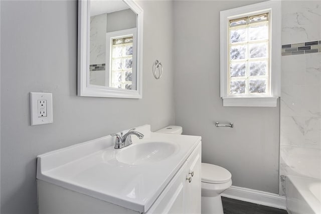 full bath featuring wood finished floors, vanity, toilet, and baseboards