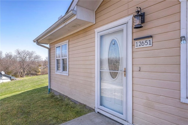 entrance to property featuring a lawn