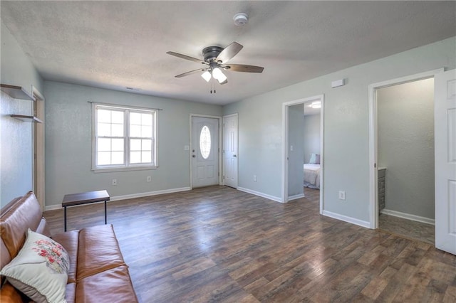 foyer with a textured ceiling, baseboards, and wood finished floors