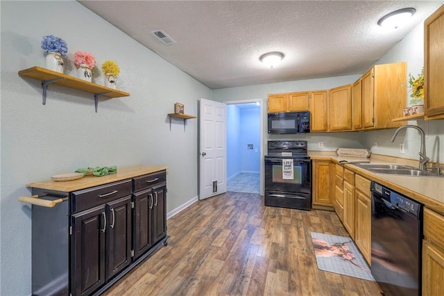 kitchen featuring wood finished floors, light countertops, black appliances, open shelves, and a sink