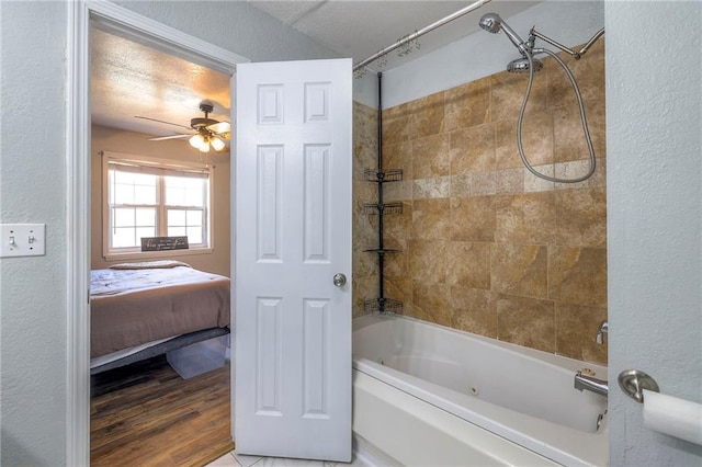 full bathroom featuring shower / bathtub combination, ceiling fan, ensuite bath, and a textured wall