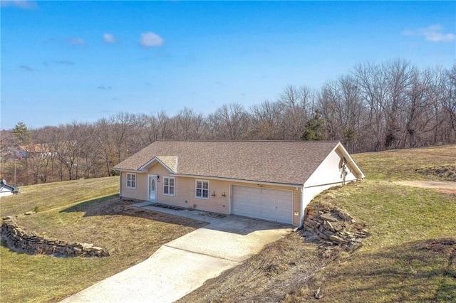 single story home with a garage, a front yard, and concrete driveway