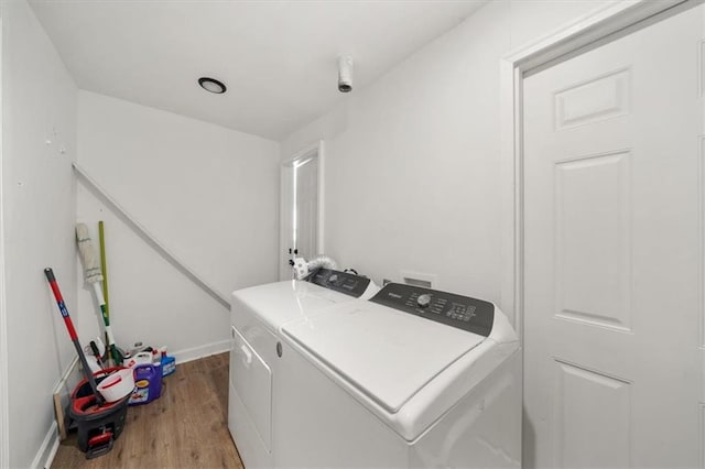 washroom with baseboards, laundry area, wood finished floors, and washer and dryer