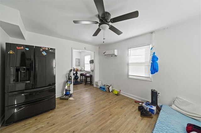 workout room featuring an AC wall unit, ceiling fan, light wood-style flooring, and baseboards