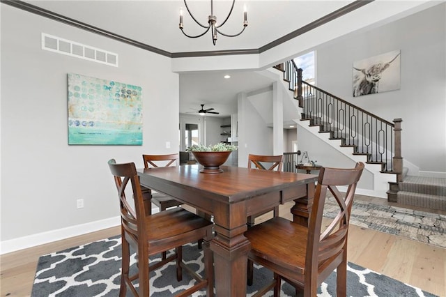 dining room with wood-type flooring, ceiling fan with notable chandelier, and ornamental molding