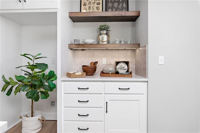 bar with decorative backsplash, white cabinetry, and wood-type flooring