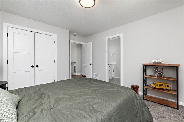 bedroom with connected bathroom, a closet, and carpet flooring