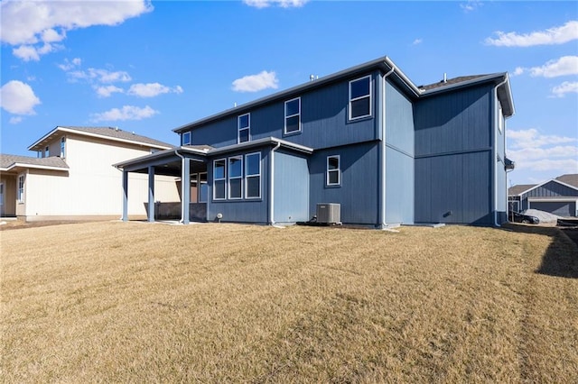 rear view of property featuring central AC and a yard