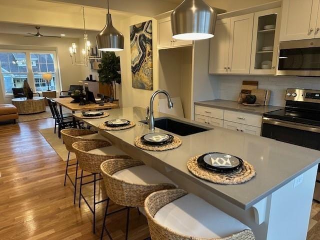 kitchen featuring white cabinetry, sink, pendant lighting, and stainless steel appliances